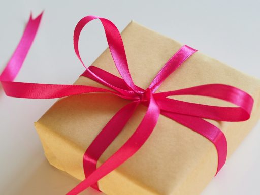 Present wrapped in brown paper and a pink satin bow.