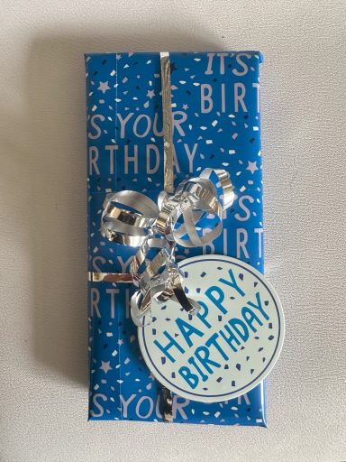 Small Rectangular Present in Blue paper which has "It's your birthday" written on