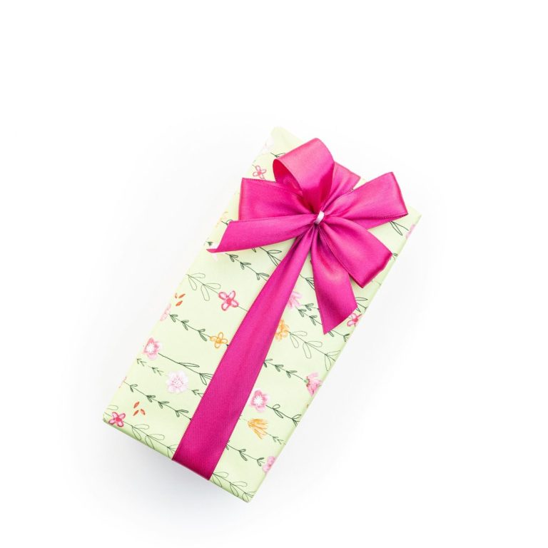 A gift wrapped in green and pink wrapping paper with a flower design on A gift wrapped in green and pink wrapping paper with a flower design on, tied with a bright pink elegant bow.