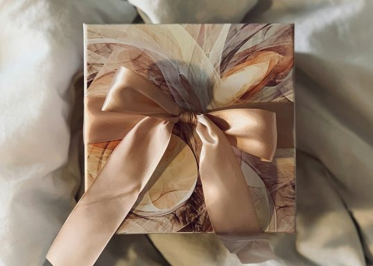 Cream, Gold & Brown gift box tied with a muted apricot satin bow.