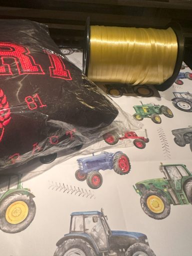 White Paper with different coloured tractors on with gold ribbon ready to be used.